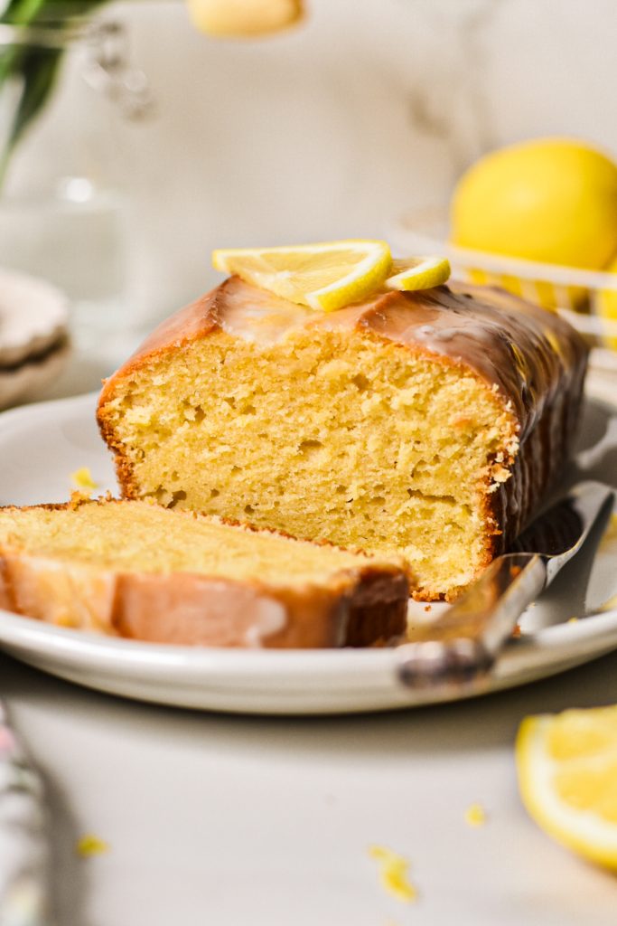 Side view of the lemon loaf cake with a slice off the end to show the inside texture.