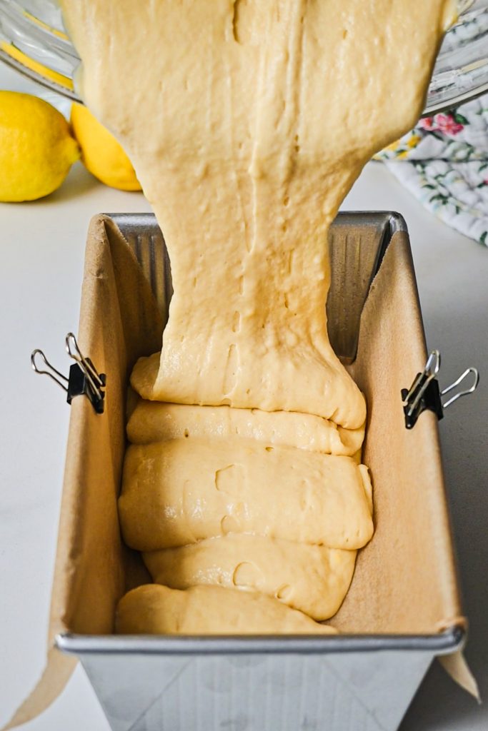 Pouring the lemon cake batter into a prepared loaf pan.