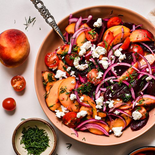 Overhead shot of peach and beet salad with feta on top.
