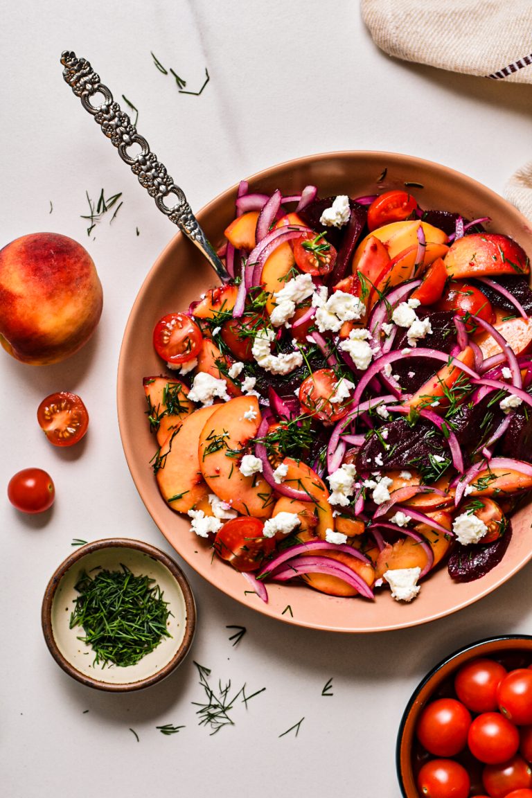 Overhead shot of peach and beet salad with feta on top.