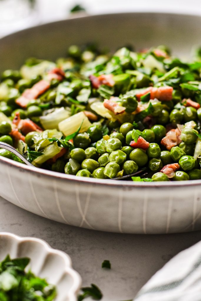 Side view of a shallow bowl filled with Peas à la Française.