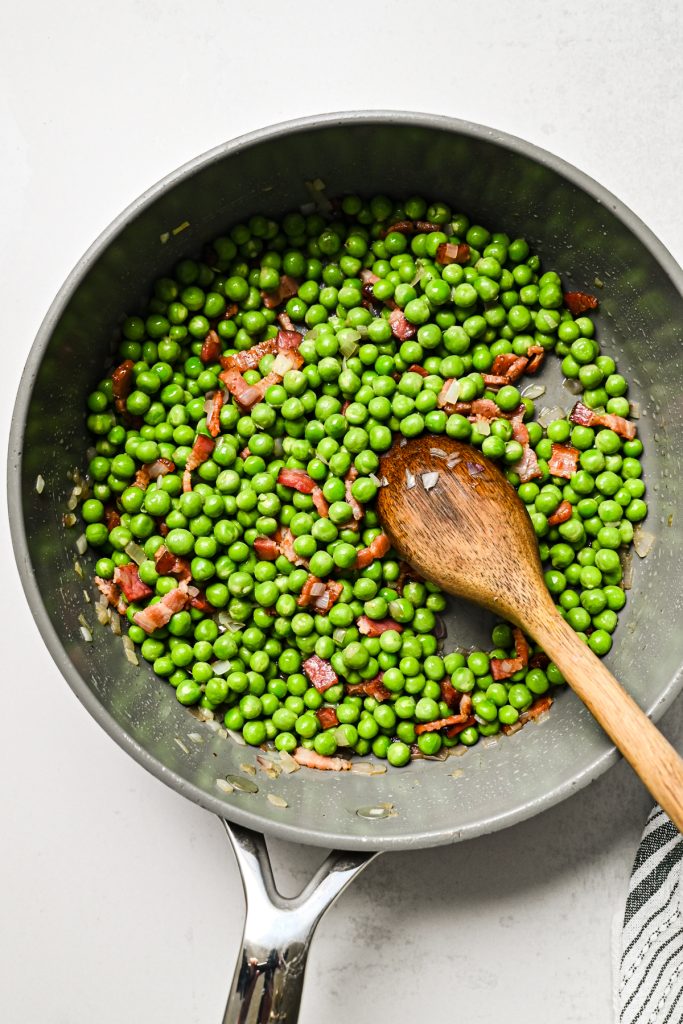Peas added to the pan with bacon and shallots.