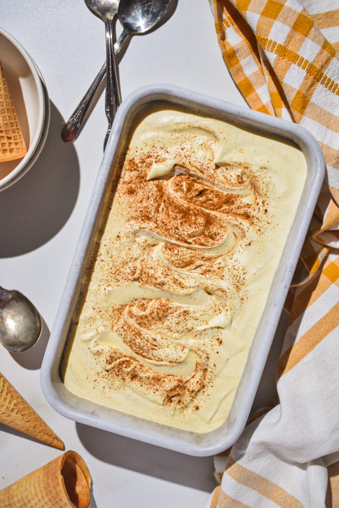 Sweet corn ice cream in a loaf pan with cinnamon on top.