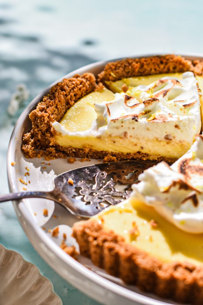 Side view of a slice of lemon tart in the serving platter to show the side layers.