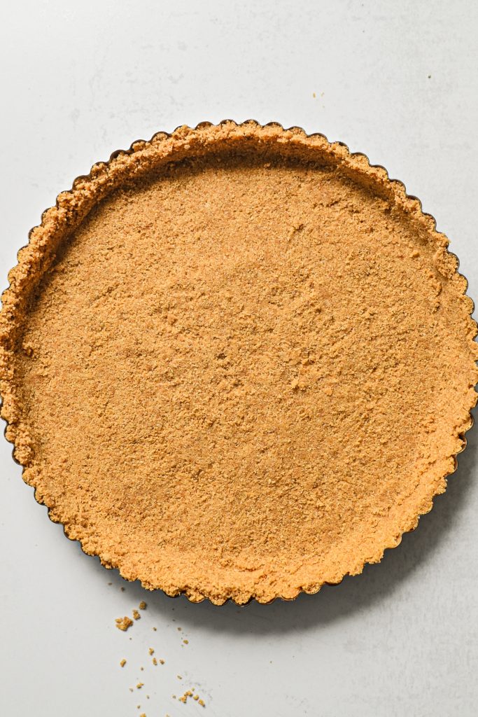 Graham cracker crust pressed into a tart pan.