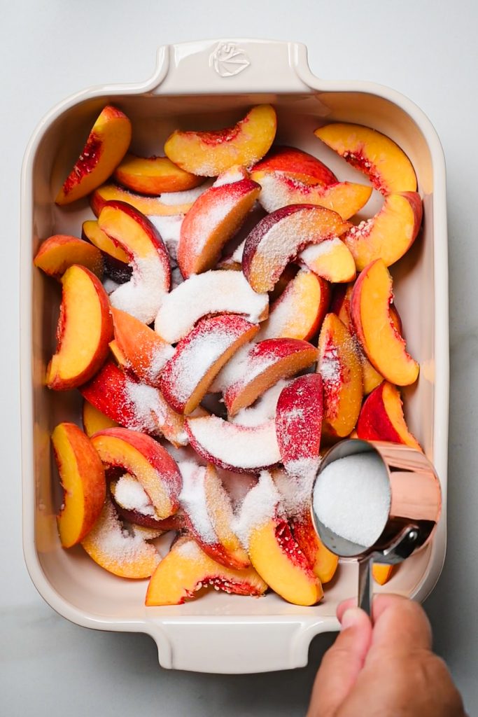 Sliced peaches with sugar poured on top.
