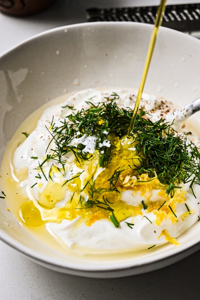 Making the dill yogurt sauce in a bowl.