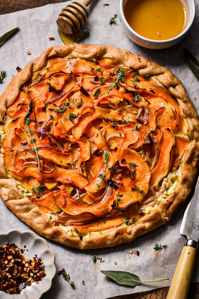 Finished butternut squash and goat cheese galette garnished with thyme and honey.