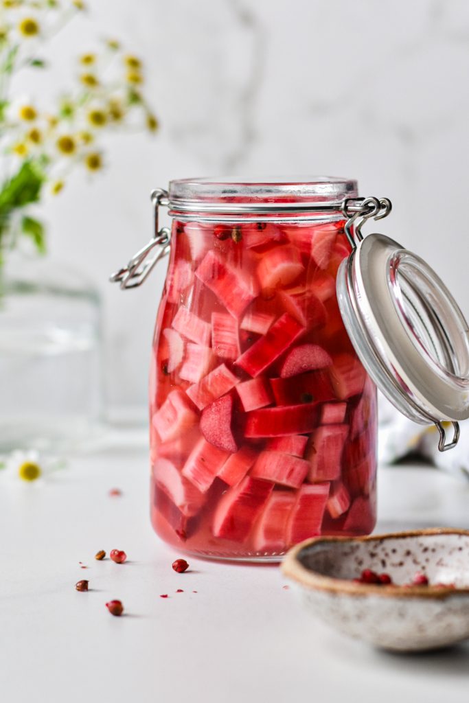 Side view of pickled rhubarb in a large jar.