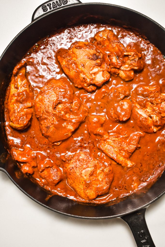 Chicken al pastor simmering in a skillet.