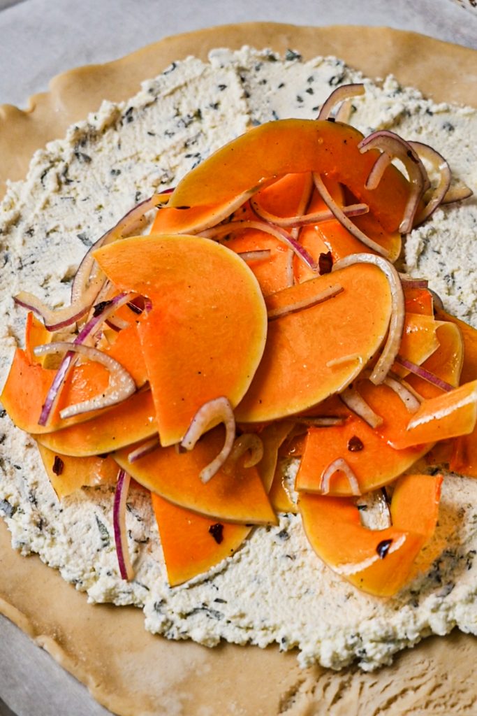 Butternut squash and red onion mixture on top of the layer of goat cheese.