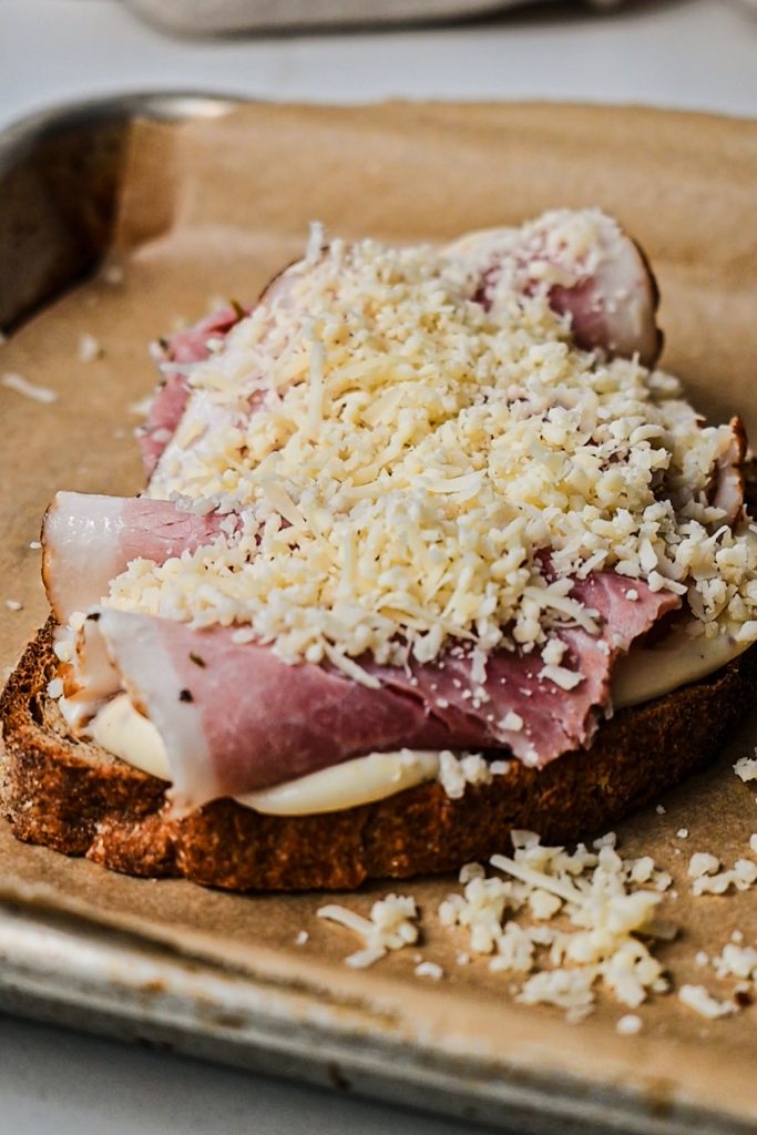 Shredded gruyere cheese on top of the layer of ham.