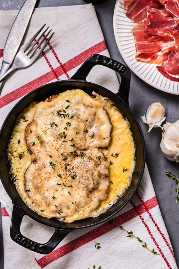 Croûte au fromage in a cast iron skillet garnished with thyme.