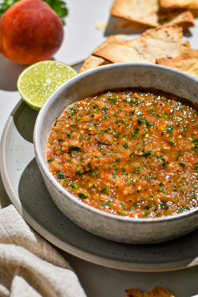 Side view of grilled peach and tomato salsa in a serving bowl.