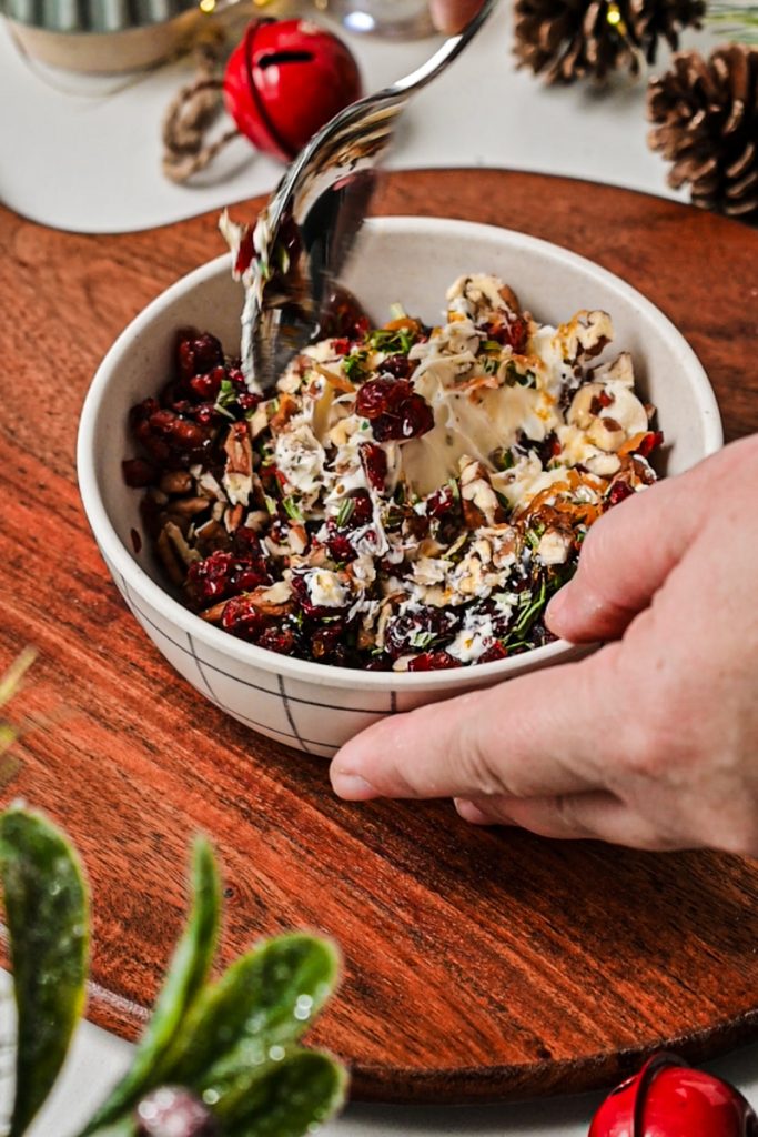 Using a spoon to mix the marscapone filling together in a bowl.