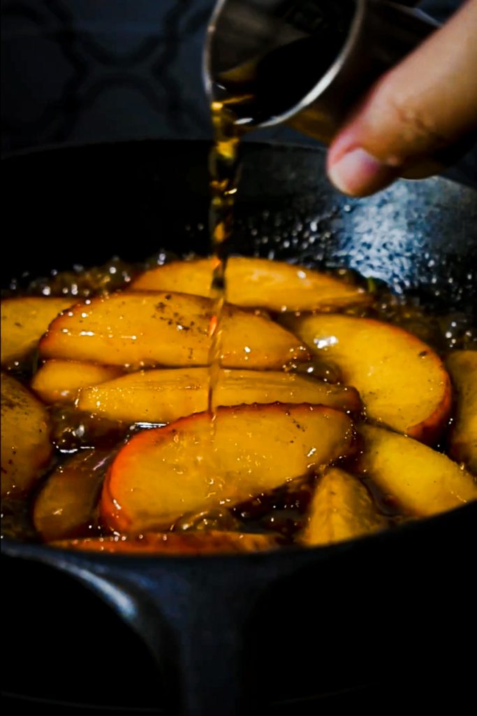 Adding alcohol to the simmered apples.
