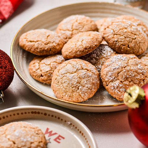 Side view of macarons de Nancy on a plate dusted with powder sugar.