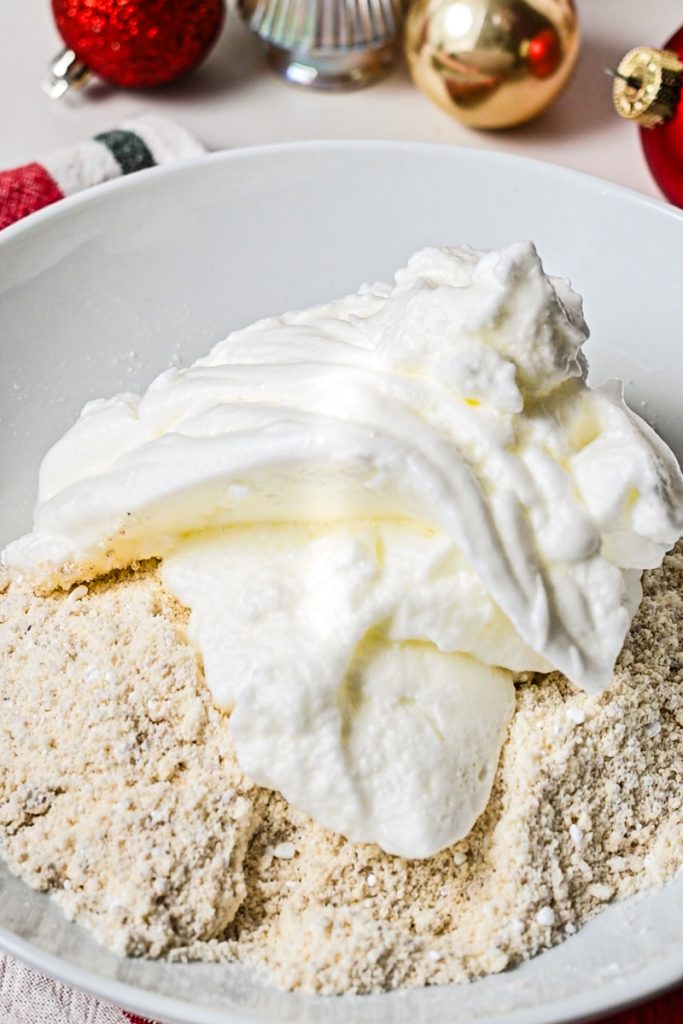 Egg whites added to the dry ingredients in a bowl.