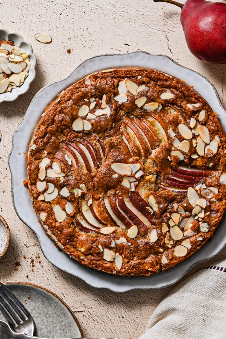 Overhead view of a spiced pear French cake on a large plate.