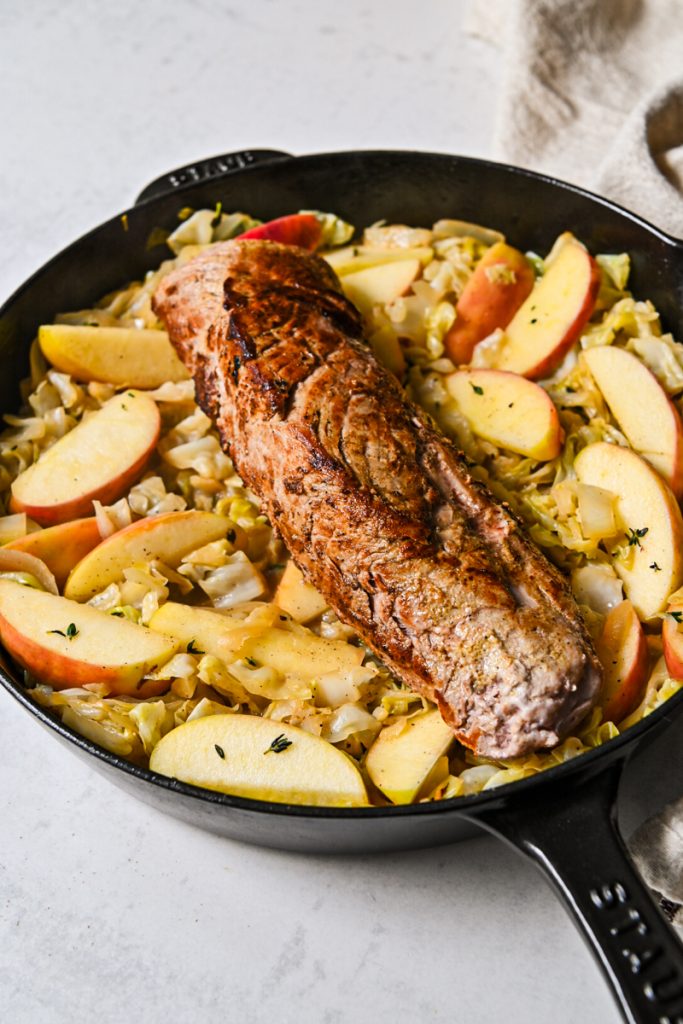 Seared pork loin placed on top of the cabbage and apples.