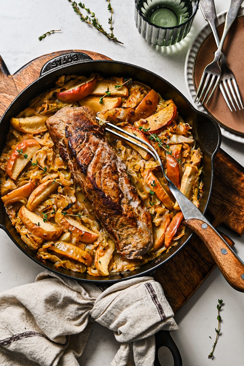 One pan pork loin with cabbage and apples in a skillet.