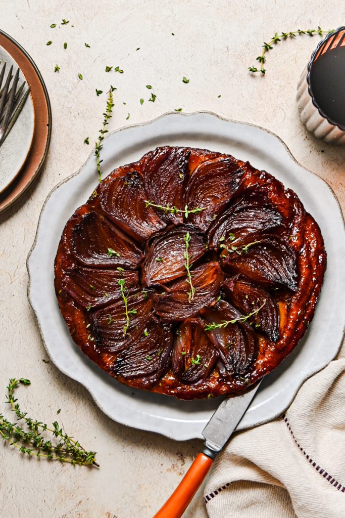 Overhead shot of red wine onion tarte tartin on a serving platter.