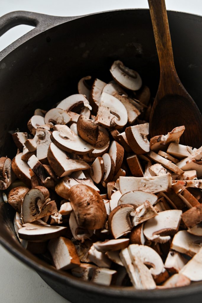 Mushrooms added to the onion in a large stock pot.
