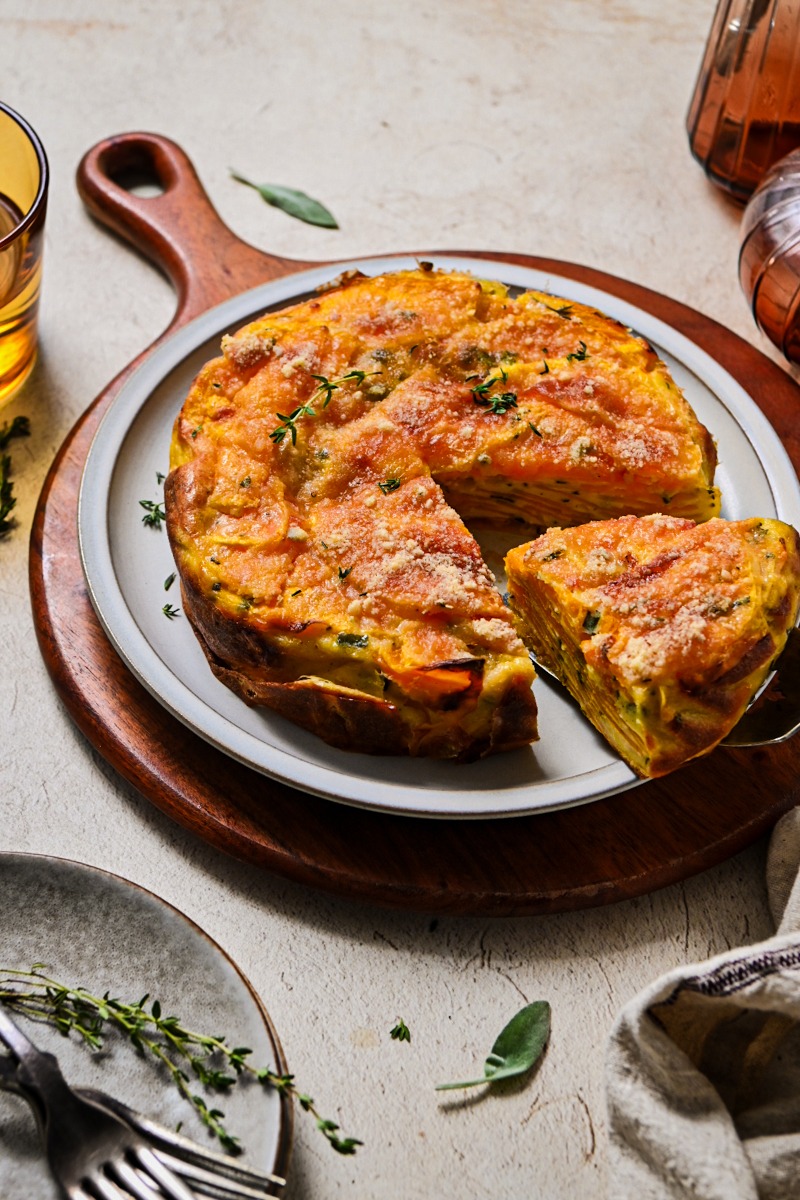 Side view of butternut squash invisible cake on a platter with a slice being taken.