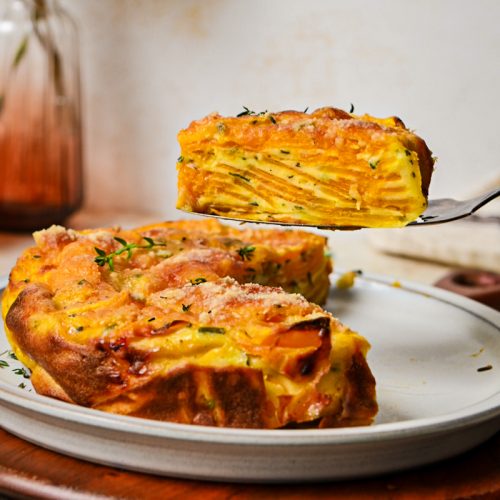 Slice of butternut squash invisible cake on a spatula hovering over the rest of the cake.