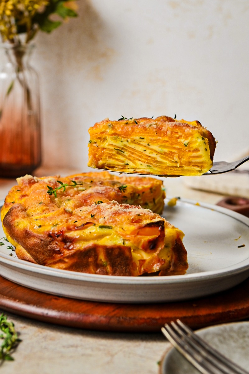Slice of butternut squash invisible cake on a spatula hovering over the rest of the cake.