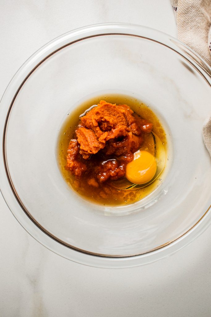 Pumpkin, maple syrup and egg in a mixing bowl.