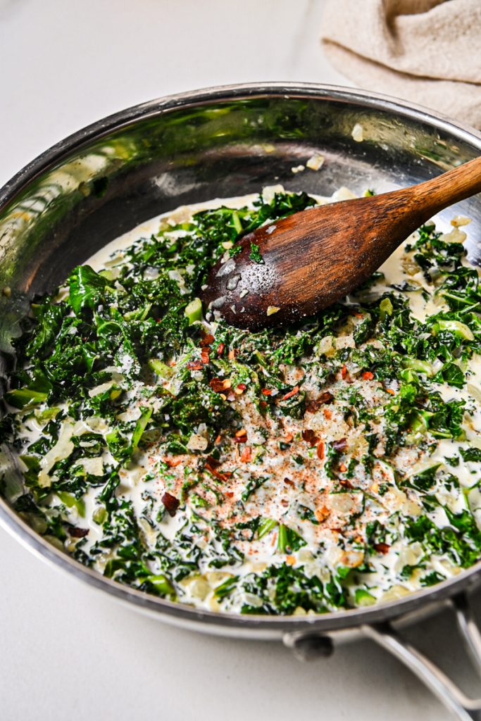 Spices and goat cheese added to the kale and heavy cream mixture.
