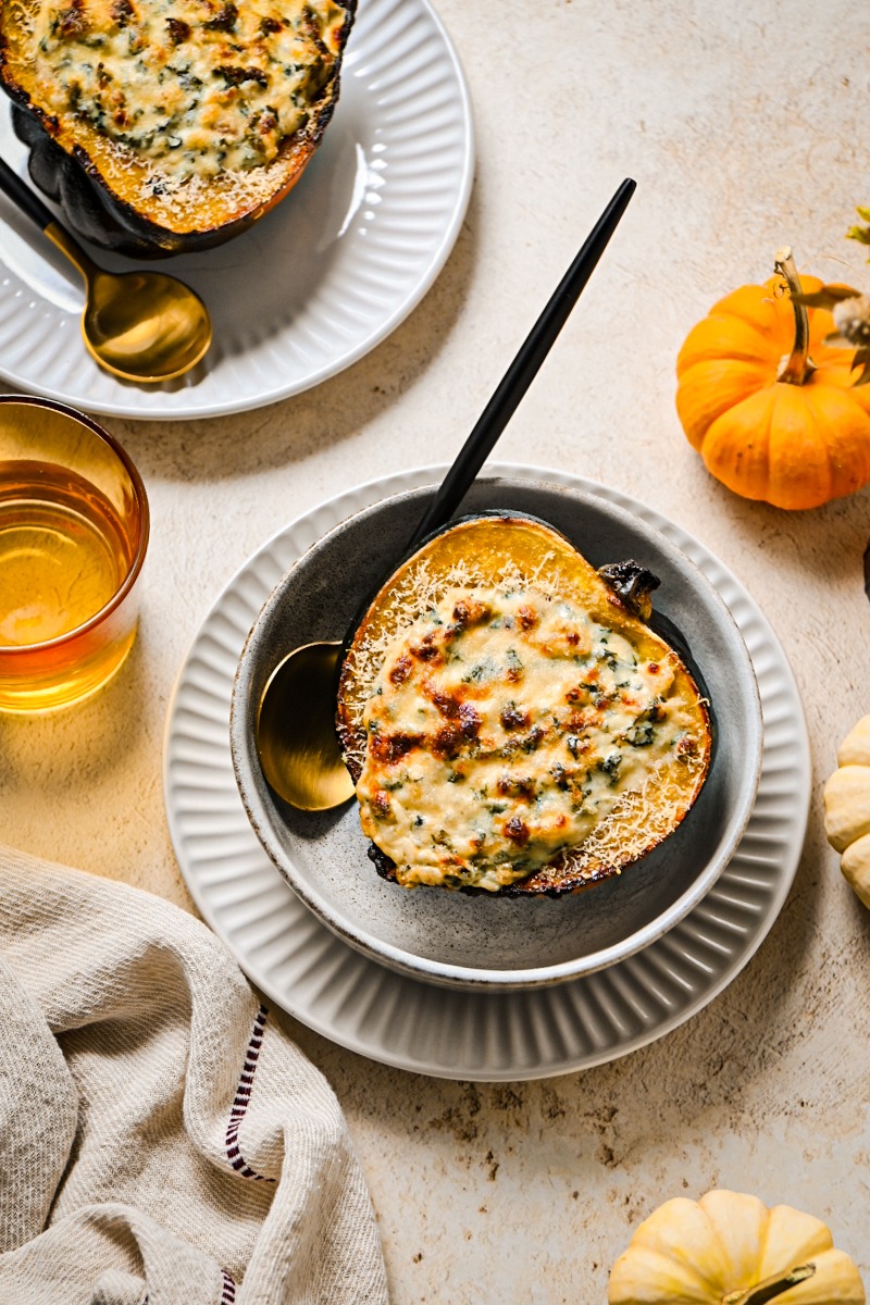 Roasted and stuffed acorn squash served in a bowl.