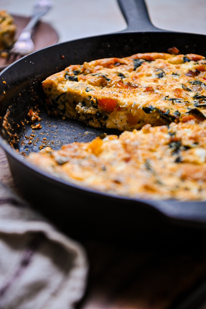 Side view of baked butternut squash quiche with a slice missing.