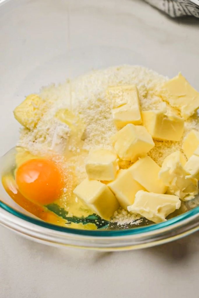 Butter, flour, egg and parmesan in a bowl.