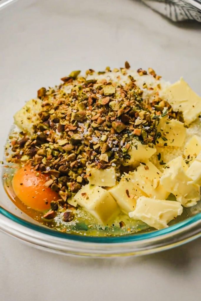 Chopped pistachios added to the butter and flour mixture in a bowl.