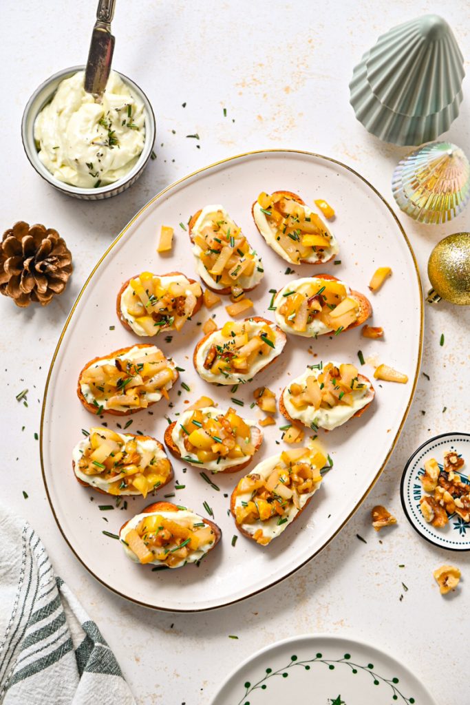 Overhead shot of whipped gorgonzola crostini with sauteed pears and walnuts and rosemary.