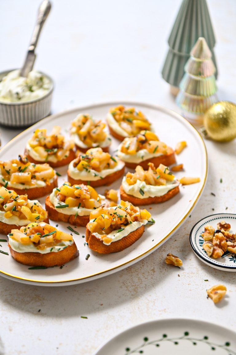 Whipped gorgonzola crostini with pears on a serving platter.