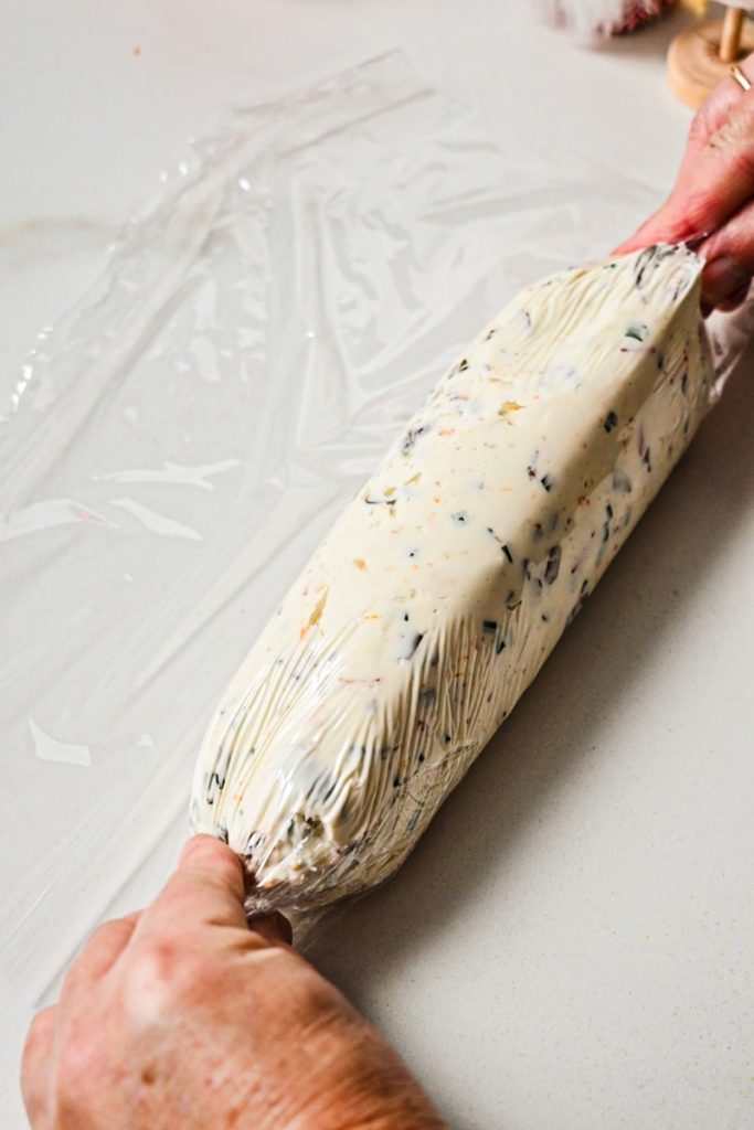 Cheese mixture wrapped in plastic wrap and shaped into a log.