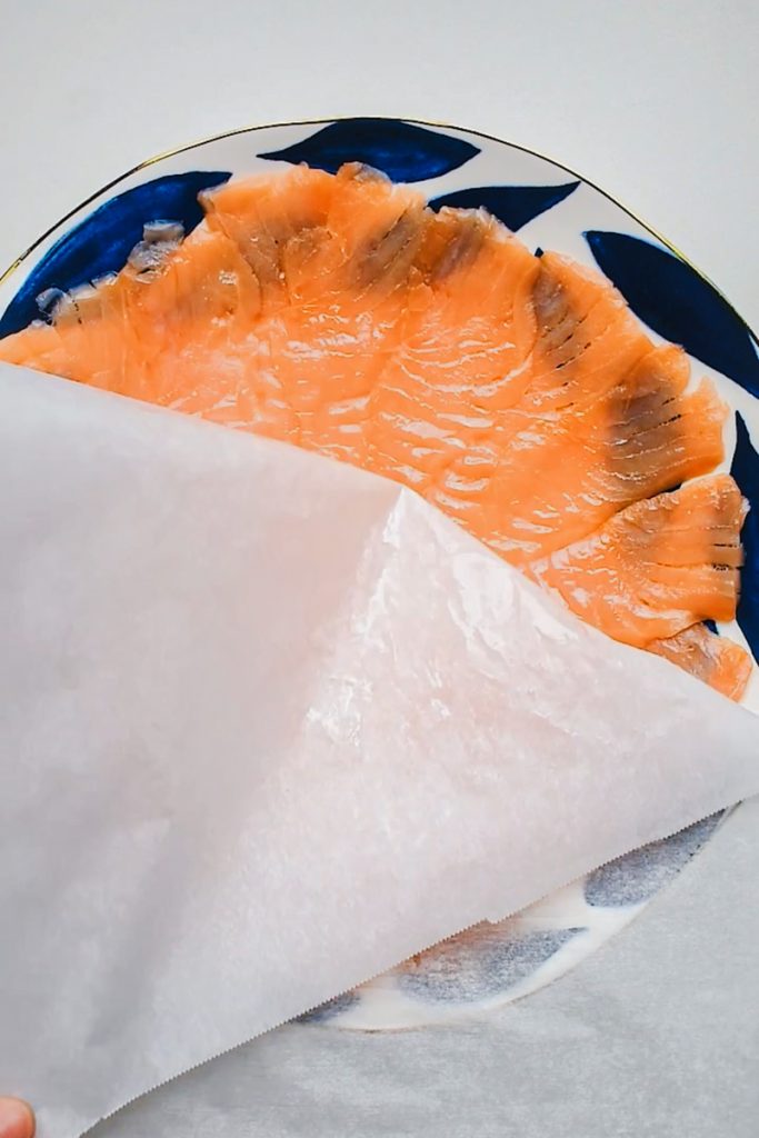 Thin pieces of smoked salmon turned out onto the plate.